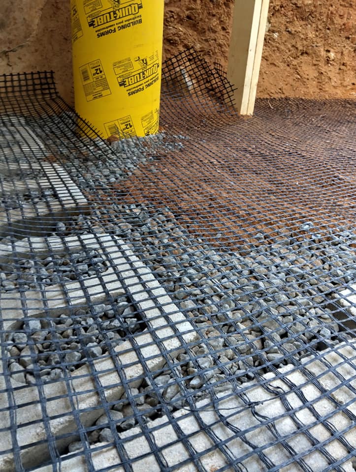 Construction site showing gravel base covered with mesh for stability and support.